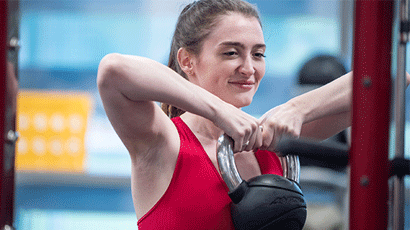 Woman in Centre for Sport lifting kettle bell.